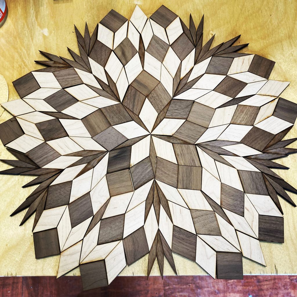 An elaborate pattern made of light and dark wooden diamonds. The pattern contains about 200 tiles, and has five-fold symmetry.