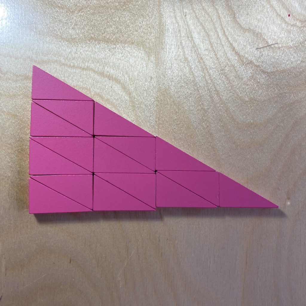 Sixteen pink right triangles tiled to make a larger, similar triangle.