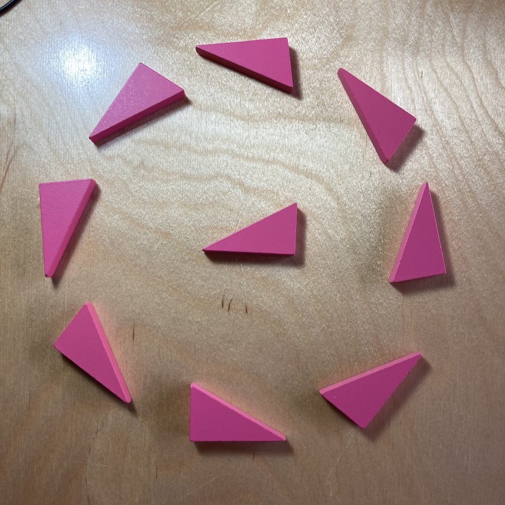 A single pink right triangle is surrounded by eight regularly spaced identical triangles in a circle, each pointing counter-clockwise around the circle.