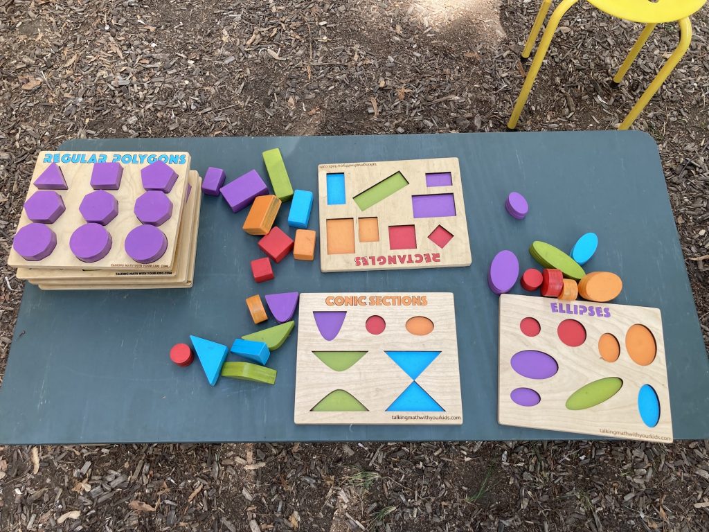 A small, low table with brightly colored wooden shape puzzles.
